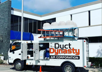 Commercial air duct cleaning truck in front of an office building.