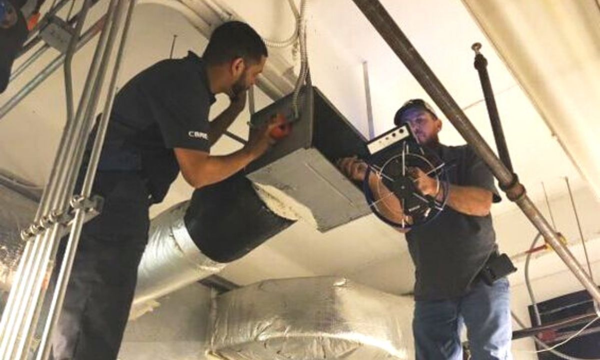 2 men crew working on a commercial HVAC system.